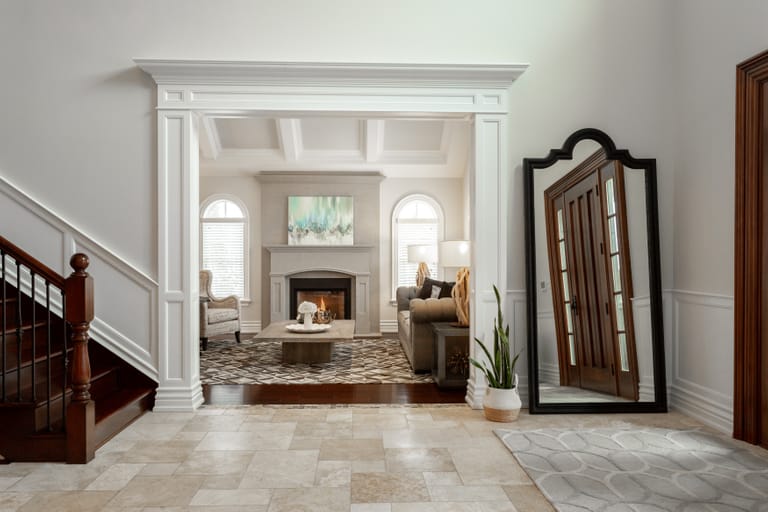 luxury foyer with corridor going into a living room with fireplace and cozy living area