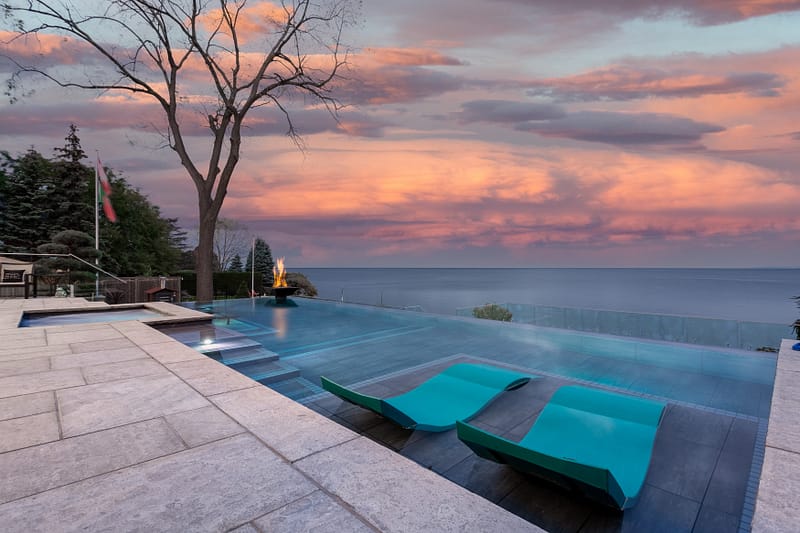 Luxury Infinity pool by Lake Ontario with fire pit for real estate